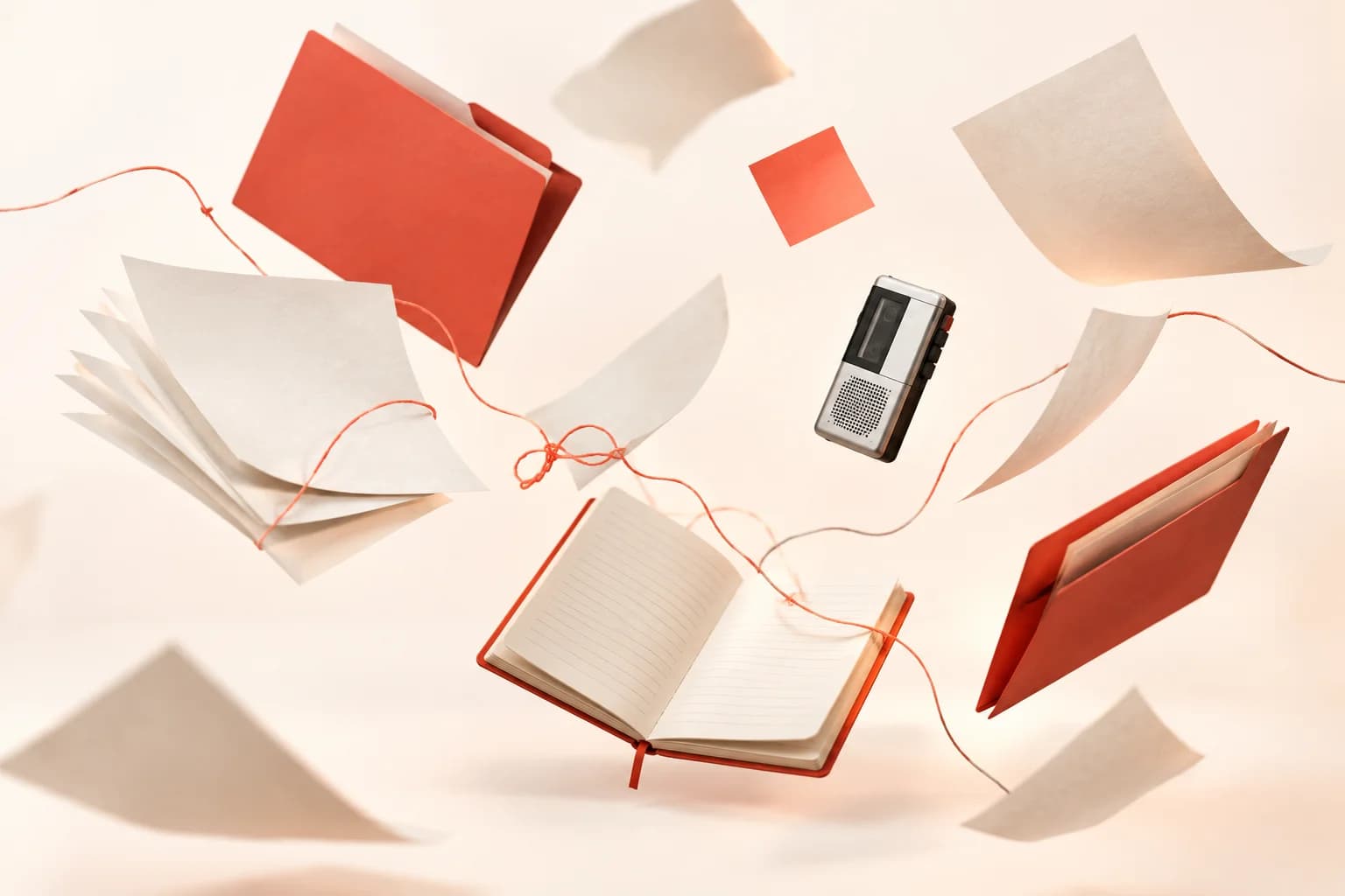 Folders, loose pages, a notebook and a voice recorder drifting apart, tied by a tangled coral thread